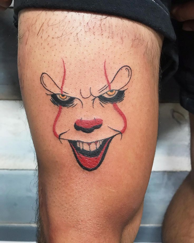 a close up of a person's leg with a scary clown face on it