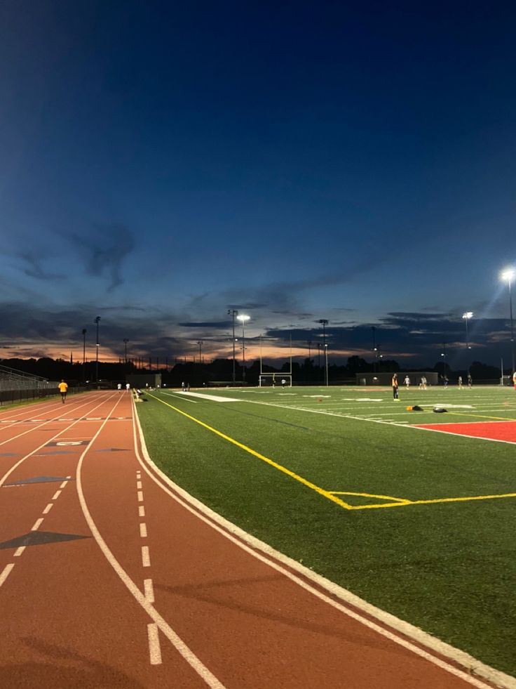 an empty sports field at night with lights on