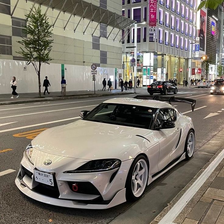 a white sports car is parked on the street