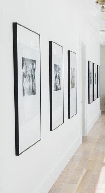 an empty hallway with pictures hanging on the wall