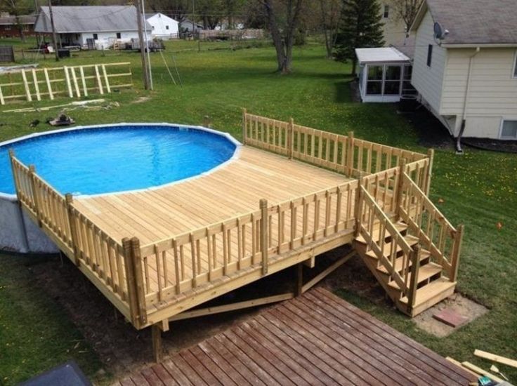 a wooden deck next to a swimming pool in a yard with an above ground plunger