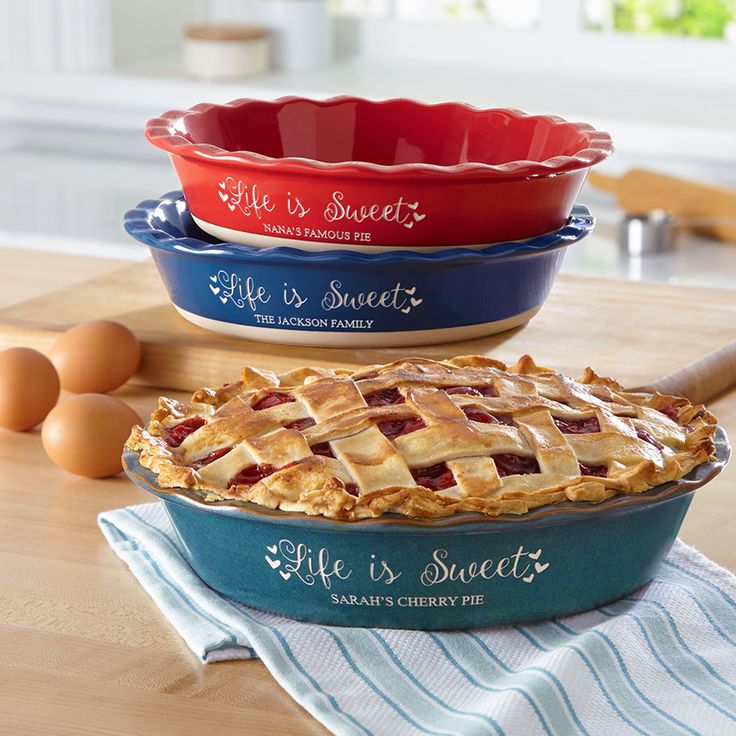 three pie dishes on a wooden table with eggs in the background and one is red, white and blue