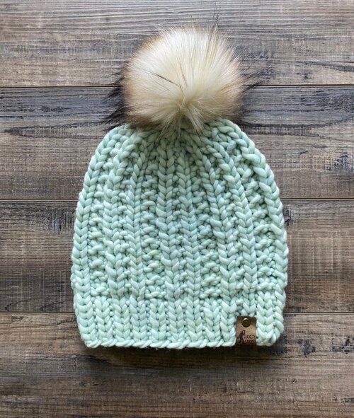 a crocheted hat with a pom - pom on top and text overlay