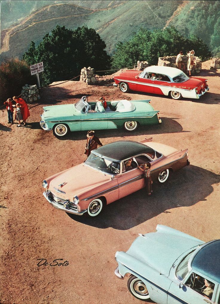 several old cars parked in a parking lot