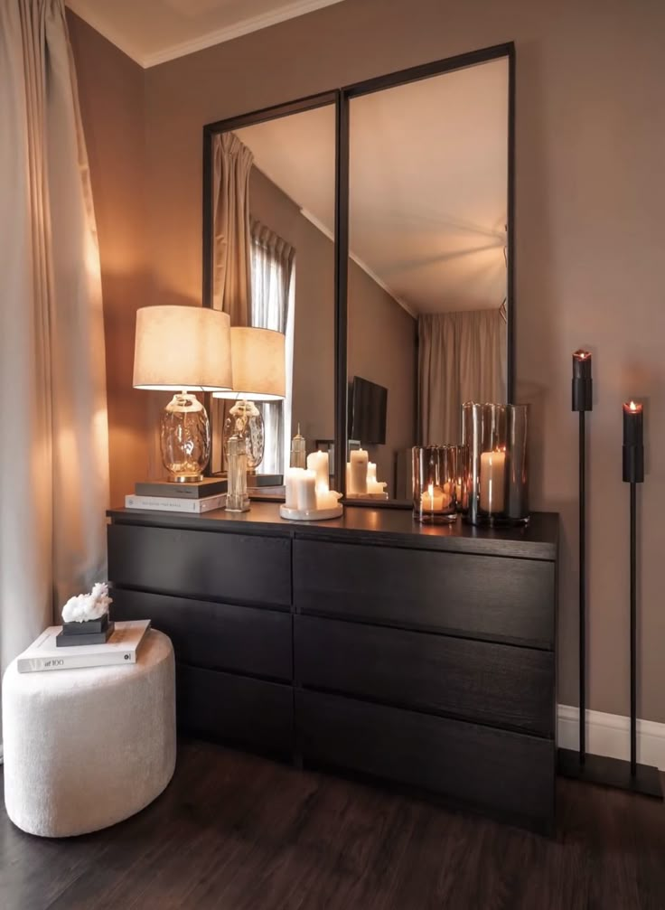 a dresser with candles on it and a large mirror