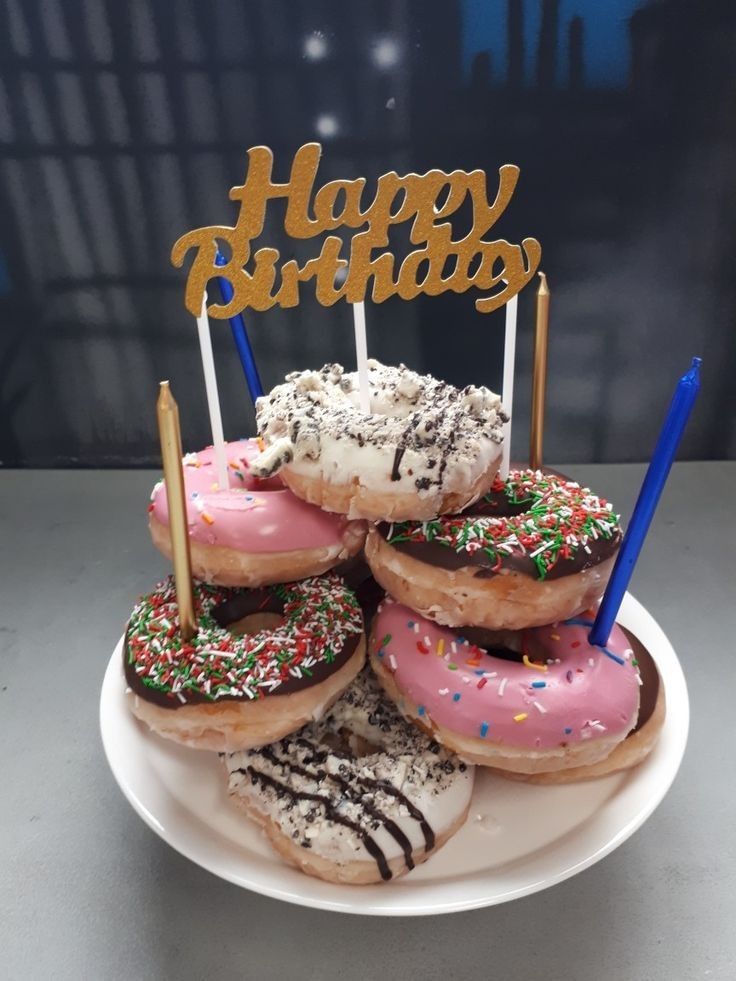 a white plate topped with donuts covered in frosting and sprinkles