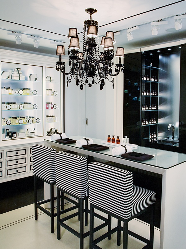 a kitchen with two bar stools and a chandelier hanging from the ceiling