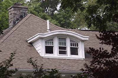 the roof of a house with a chimney and windows