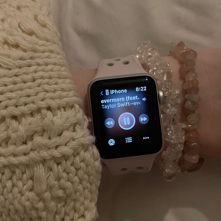 a person wearing a bracelet and watch on their wrist with an apple watch in the background