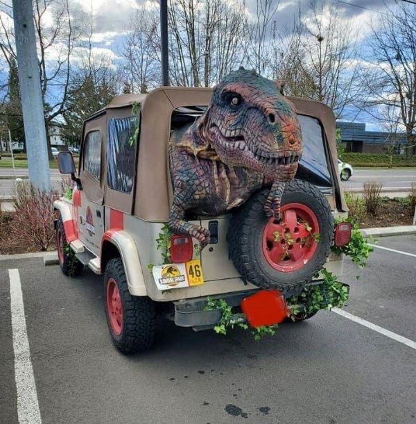 a jeep with an alligator on the back parked in a parking lot