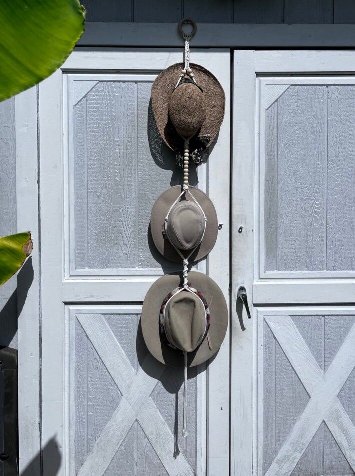 three hats hanging on the side of a garage door