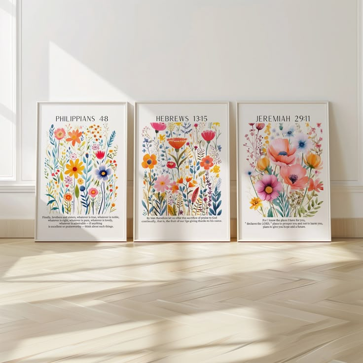 three floral posters on the wall in an empty room with wood flooring and white walls