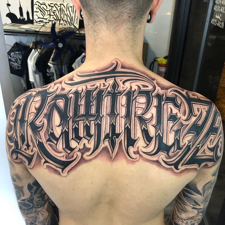 the back of a man's upper and lower half - sleeved tattoo