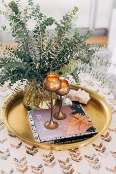 there is a vase with some flowers in it and a book on the table next to it