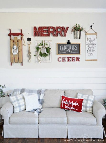 a living room with christmas decorations on the wall and signs above the couch that say merry