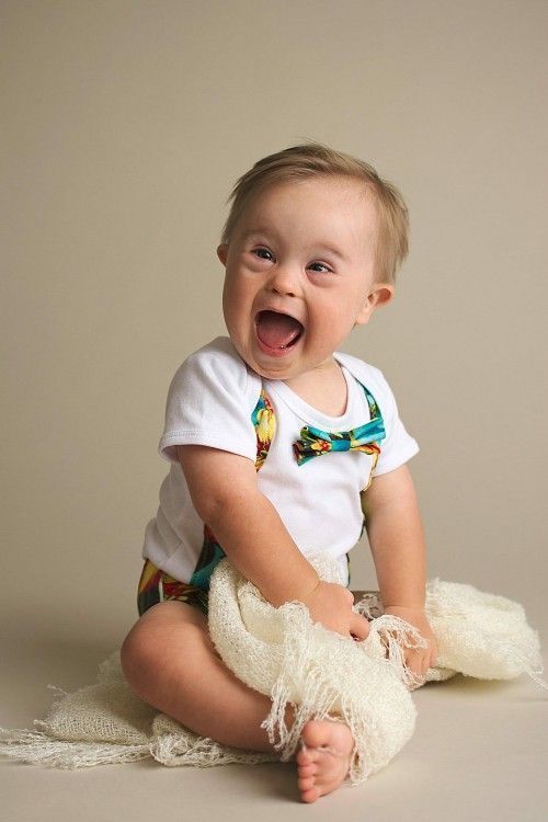 a baby sitting on the floor with his mouth open