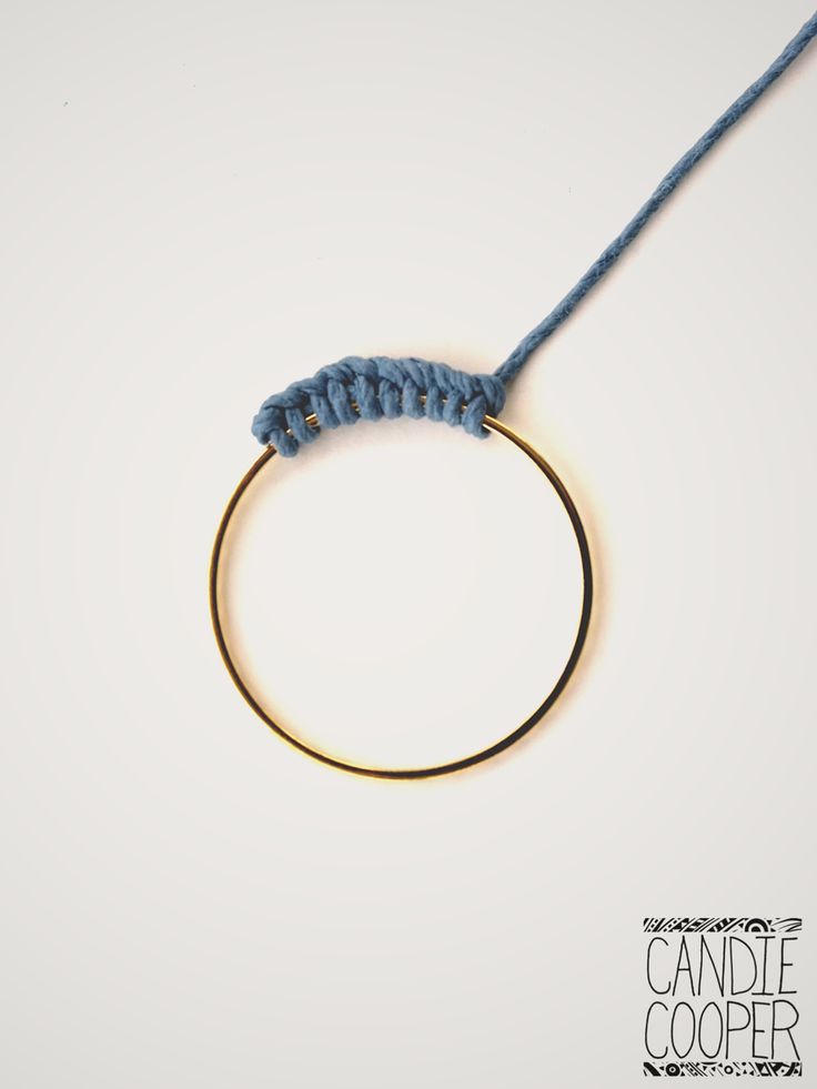 a blue string is attached to a gold ring with a black cord on it,