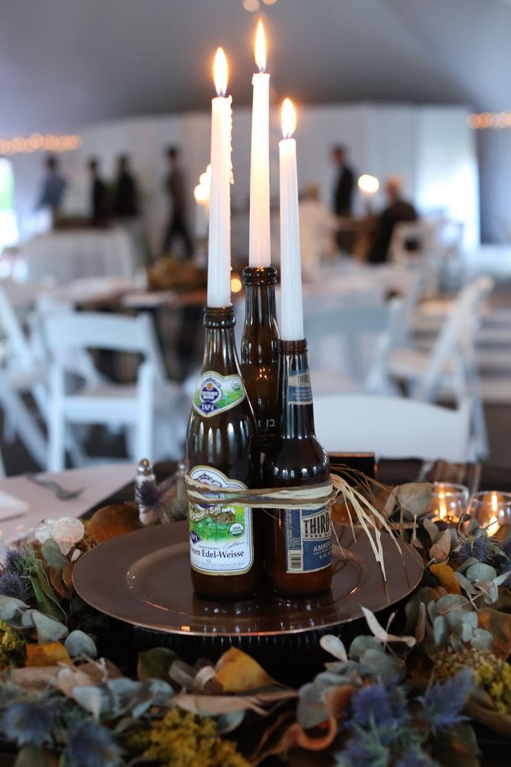 a table topped with two beer bottles and candles