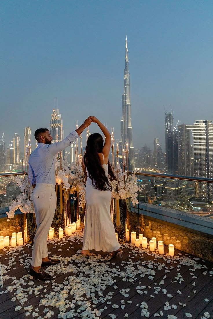 a man and woman dancing on top of a building