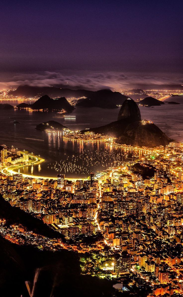 an aerial view of the city lights and mountains at night, as seen from above