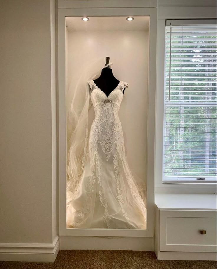 a wedding dress is displayed in a window