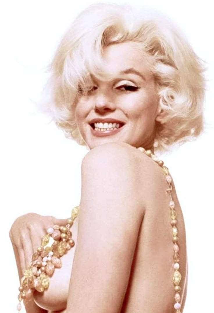 marilyn monroe is smiling and posing for the camera with her hand on her hip while wearing a beaded dress