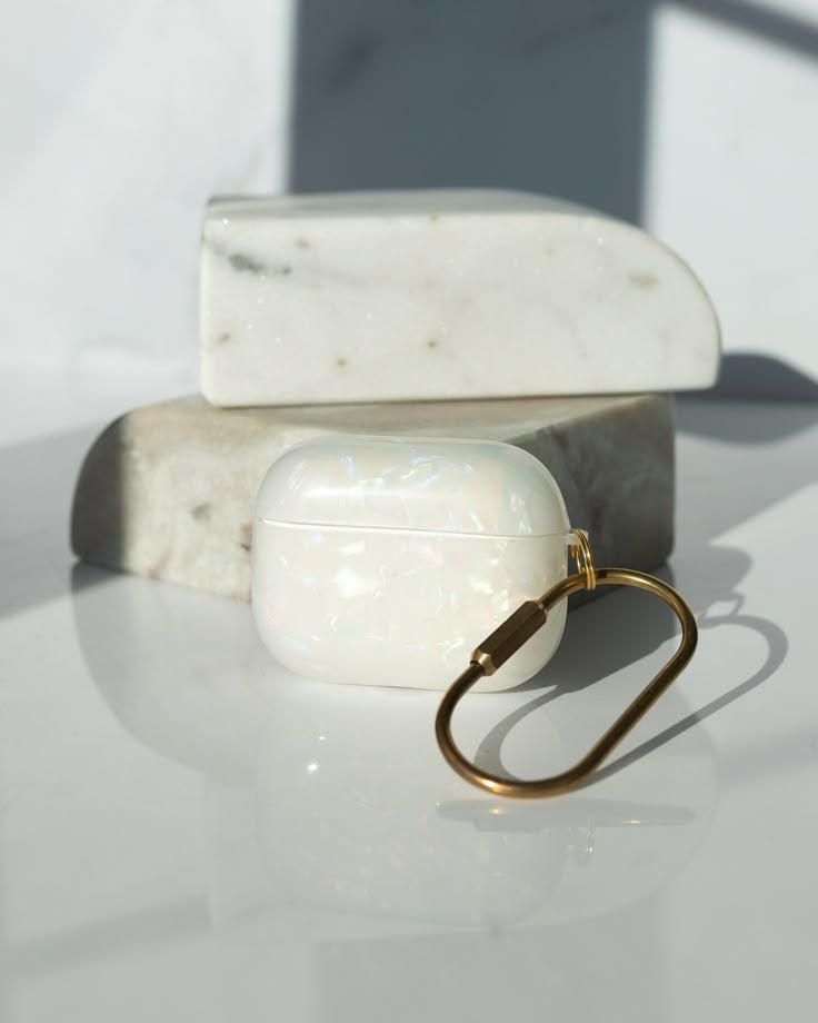 two soap bars sitting next to each other on top of a white table with a gold ring