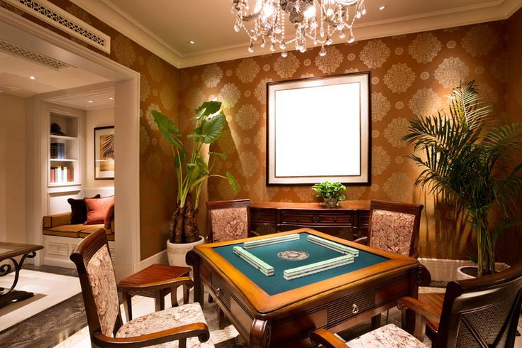 a dining room table with chairs and a large window in the corner, next to a potted plant