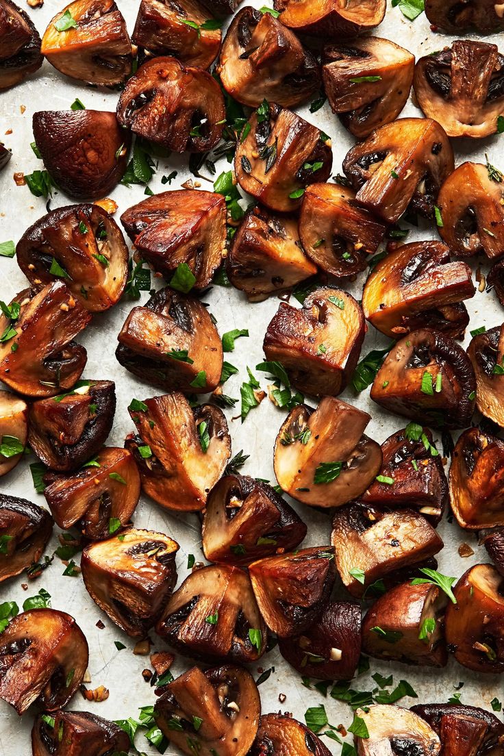 cooked mushrooms with parsley on a sheet of parchment paper, ready to be eaten