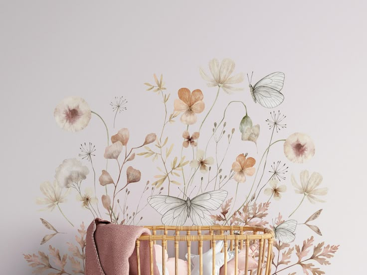 a baby crib next to a wall with flowers painted on it