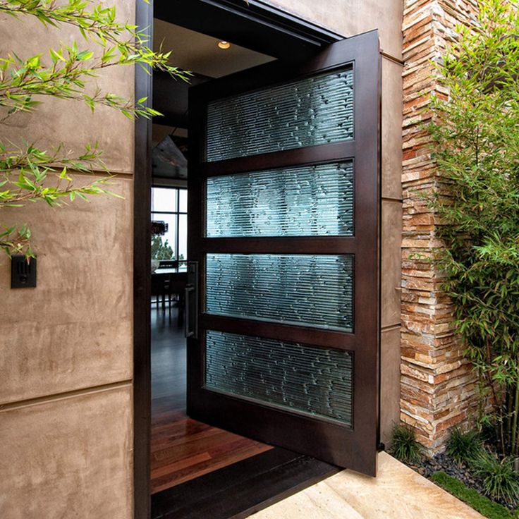 an open door leading to a house with trees in the background