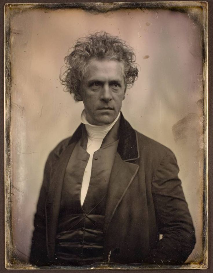 an old black and white photo of a man with curly hair