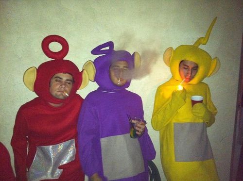 three people in costumes are standing next to each other and one is holding a lit candle