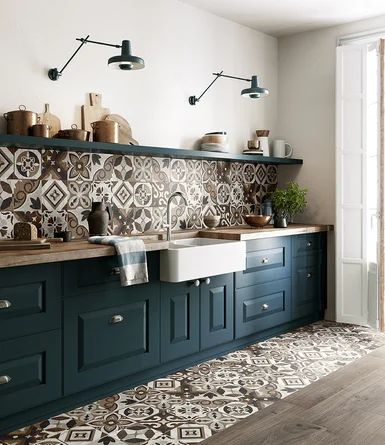 a kitchen with blue cabinets and patterned tile backsplash, wood flooring and open shelving