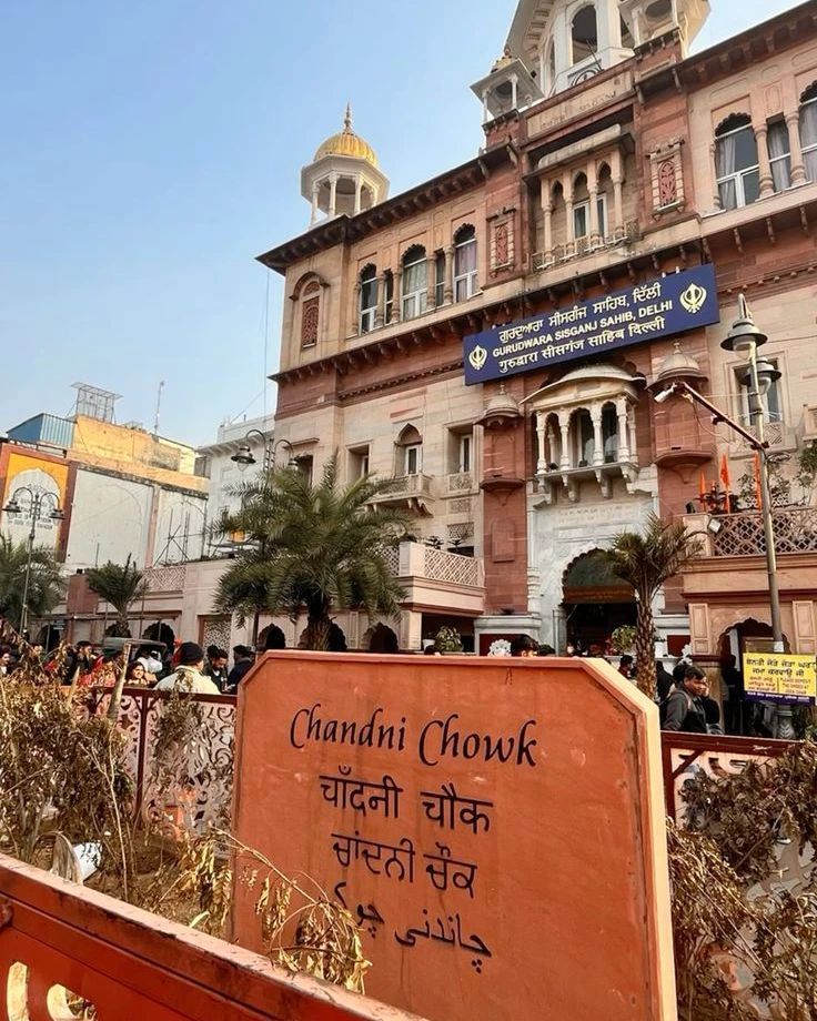 an old building with many people walking around it in front of the entrance to chandni chowk