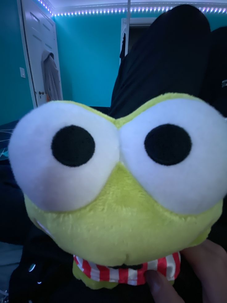 a yellow stuffed animal with big eyes on it's face