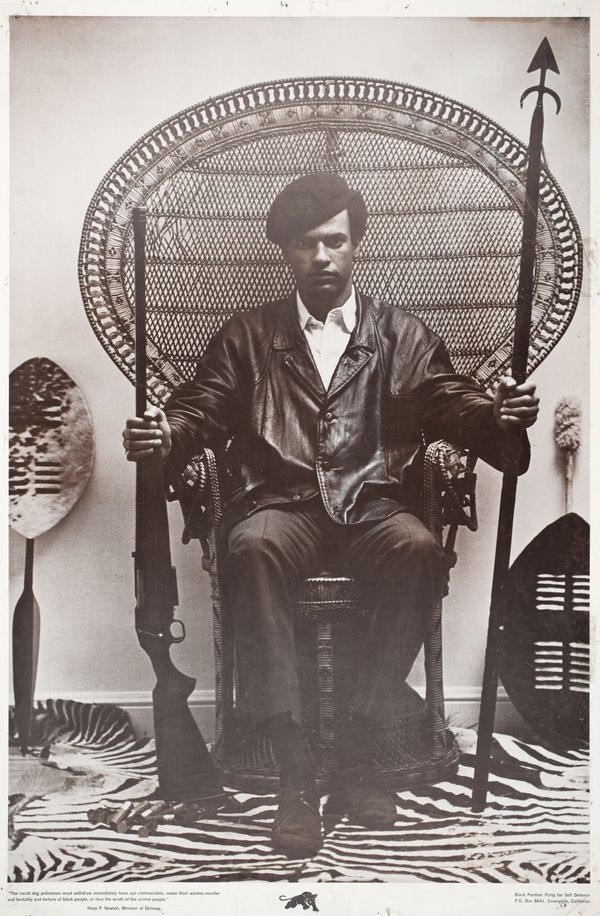 an old photo of a man sitting in a chair with two canes on his feet