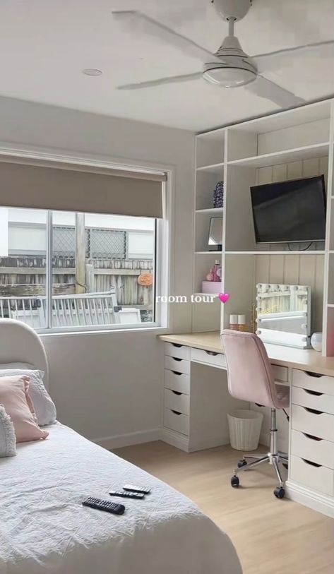 a bedroom with a bed, desk and television on the wall next to a window