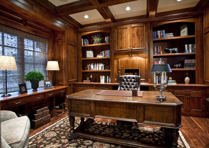 a home office with wood paneling and built in bookshelves