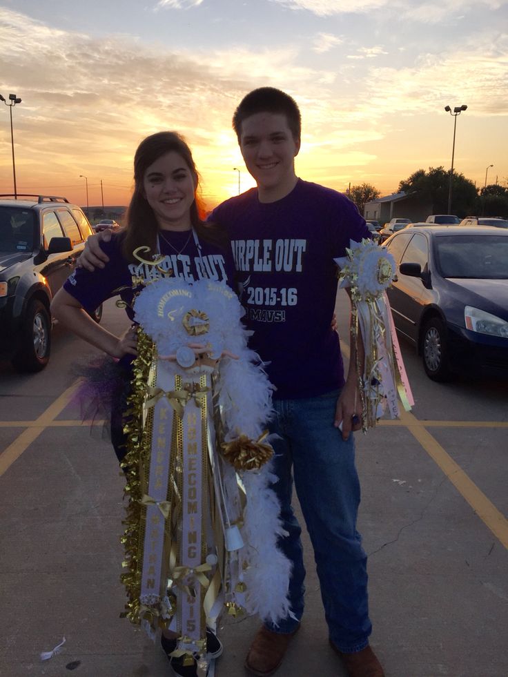 a man and woman standing next to each other in a parking lot