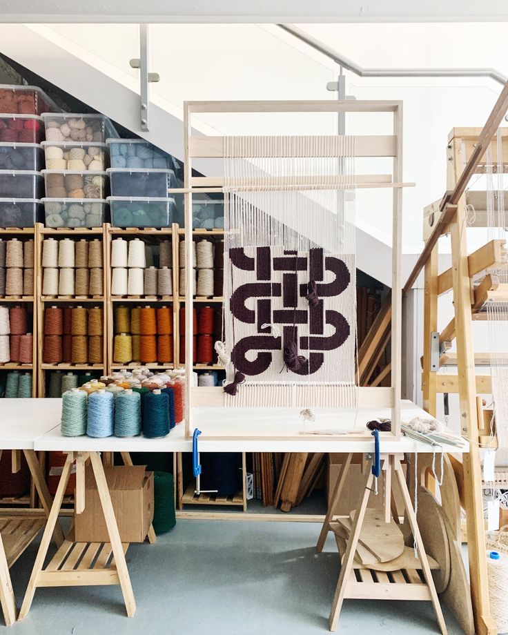 an art studio with many different colored spools of thread on the tables and shelves