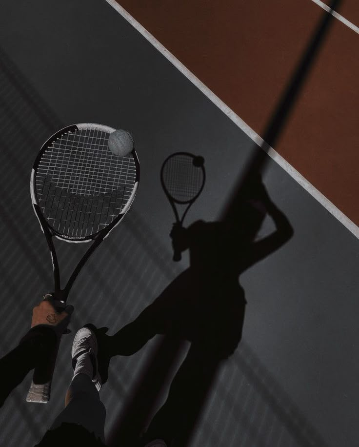 the shadow of a person holding a tennis racket