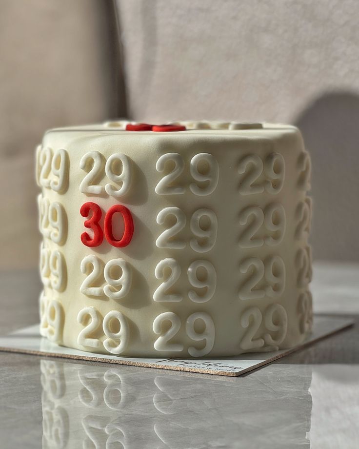 a white cake with red numbers on it