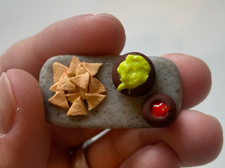 a person holding a tiny rock with food on it