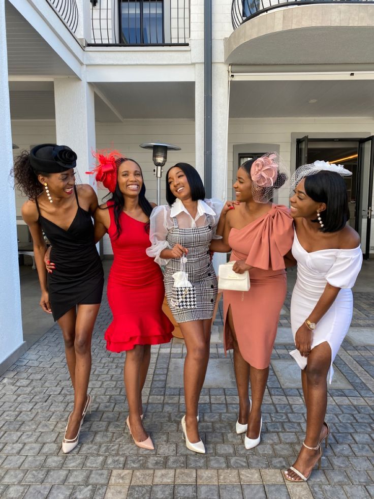 four women in dresses are posing for the camera