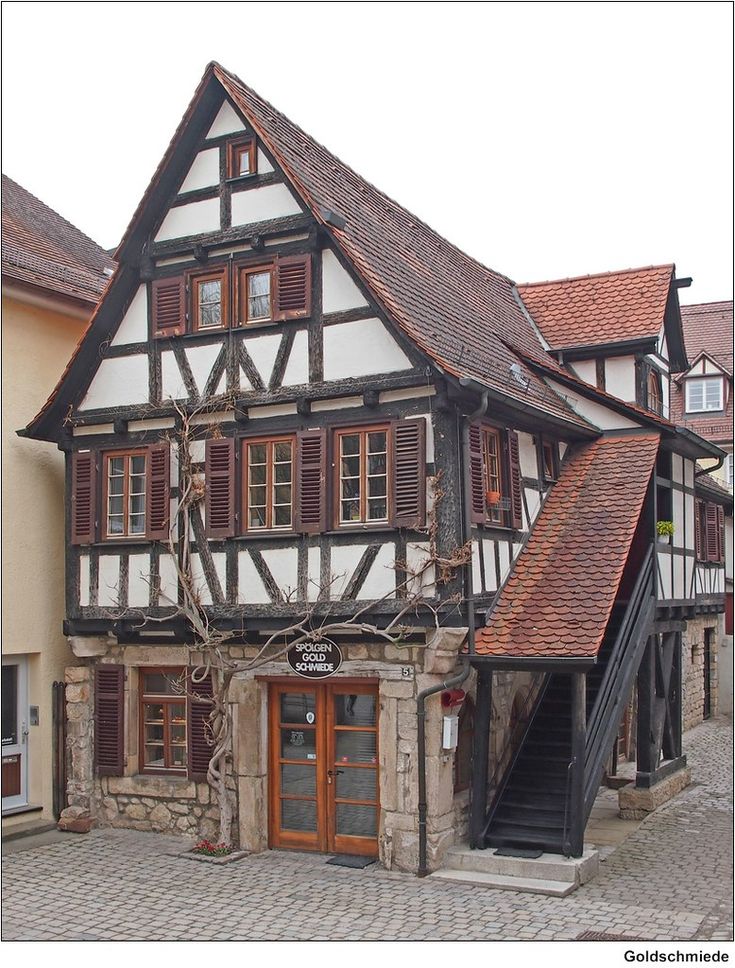 an old building with wooden shutters on the front and side windows, in germany