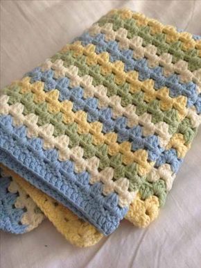 two crocheted dishcloths sitting on top of each other in blue, yellow and green