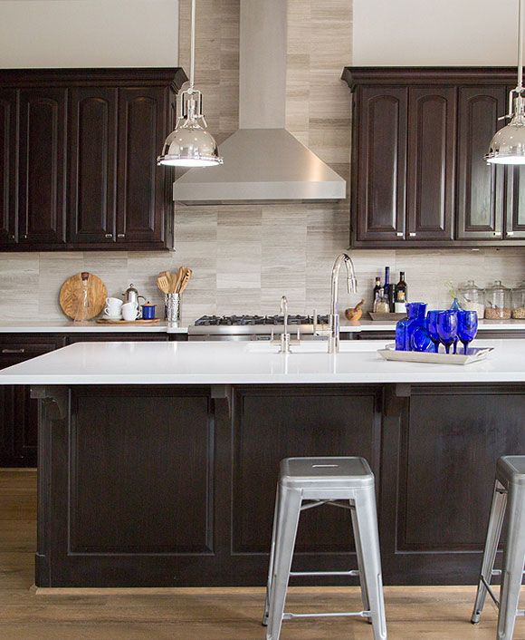 a kitchen with dark wood cabinets and white counter tops