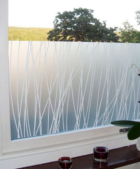 a vase with some flowers in it sitting next to a window sill on a windowsill