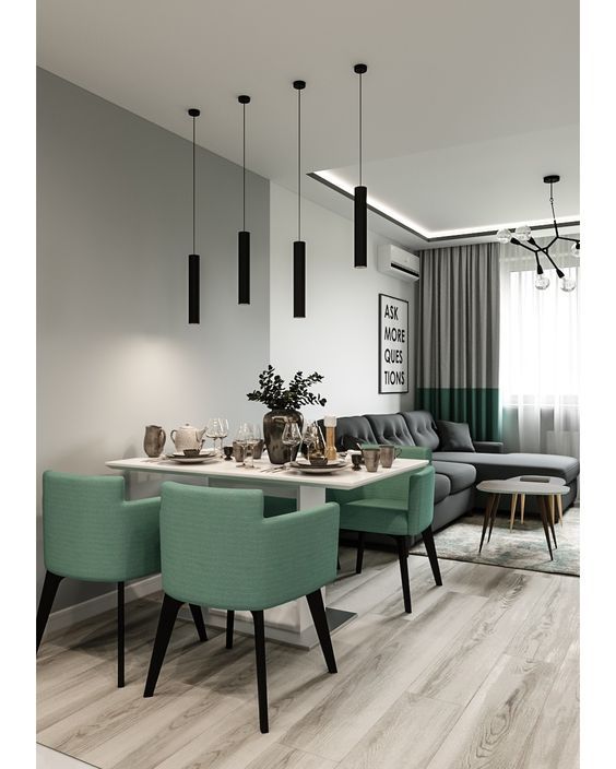 a dining room table and chairs in front of a living room with grey walls, wood flooring and black pendant lights